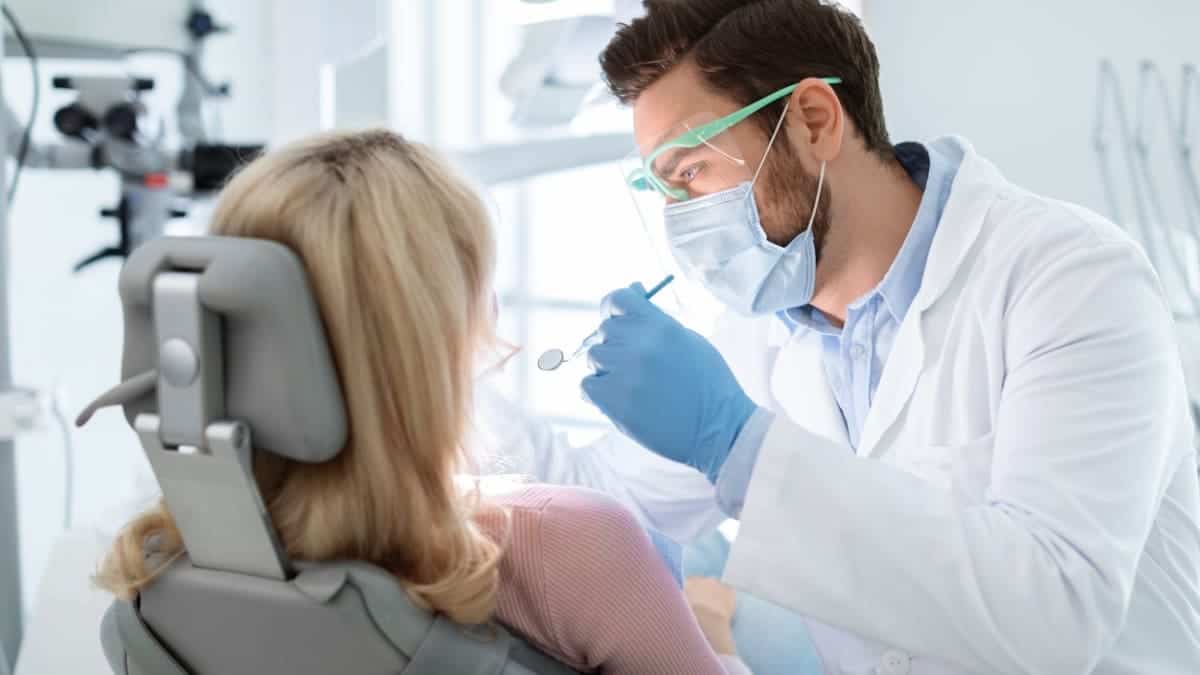 Patient receiving professional teeth whitening with a laser device Telford